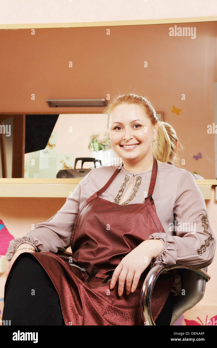 Smiling hairdresser in chair Stock Photo