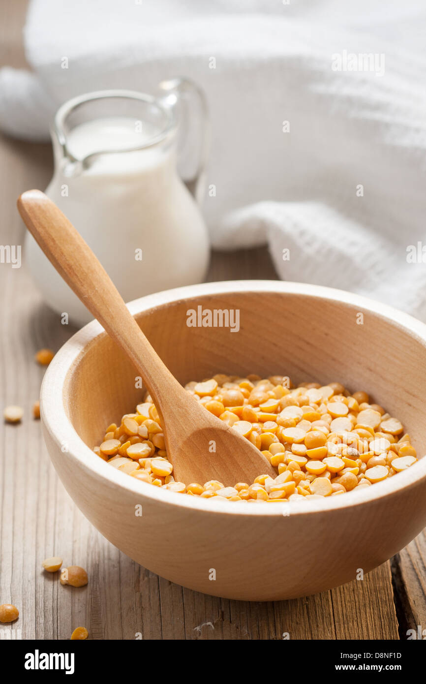 A wooden bowl of dry peas and a jug of milk Stock Photo