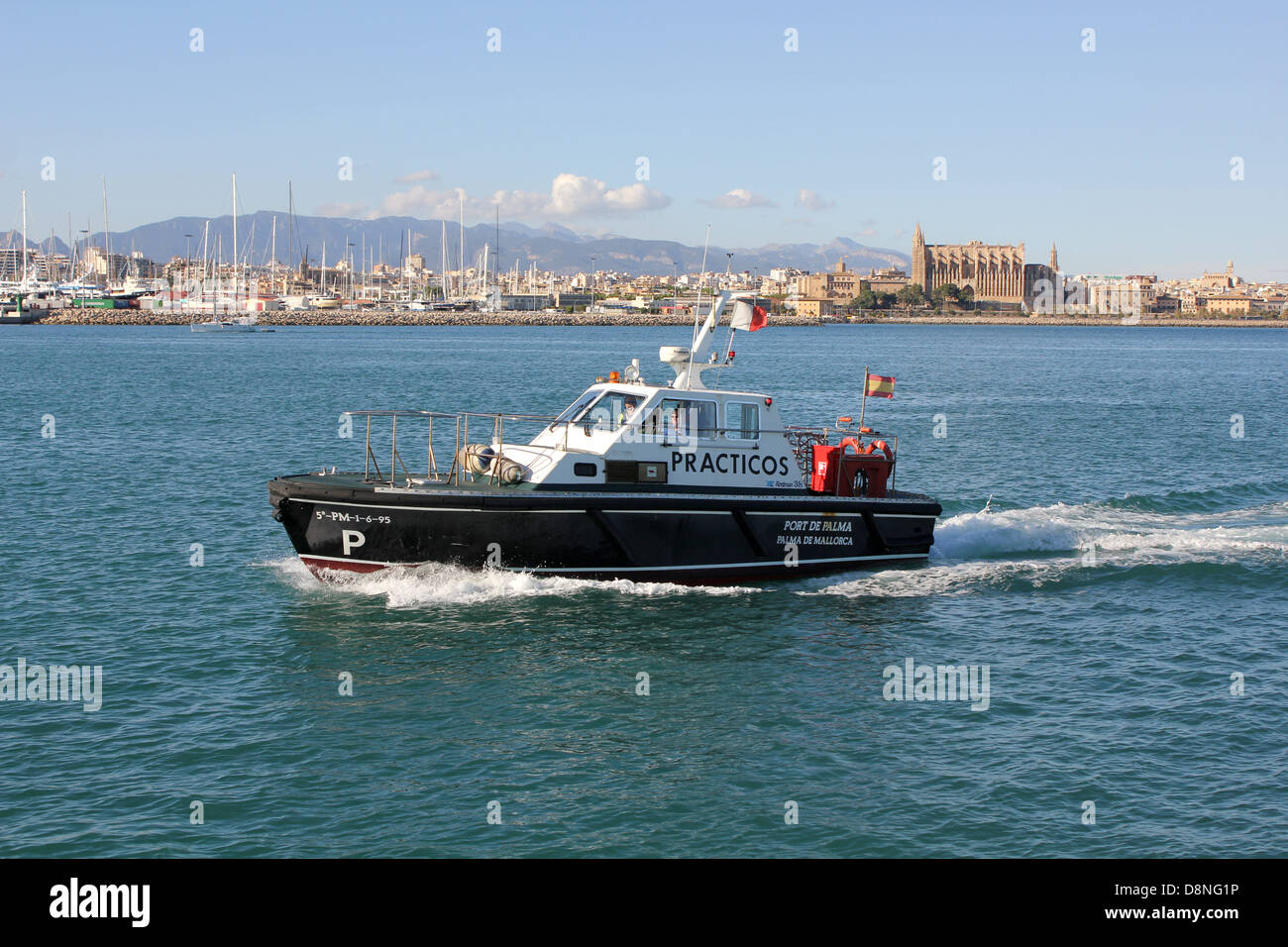 Port Pilot Service (PRACTICOS) launch returning to port past historic Palma Gothic Cathedral - of in the Port of Palma Stock Photo