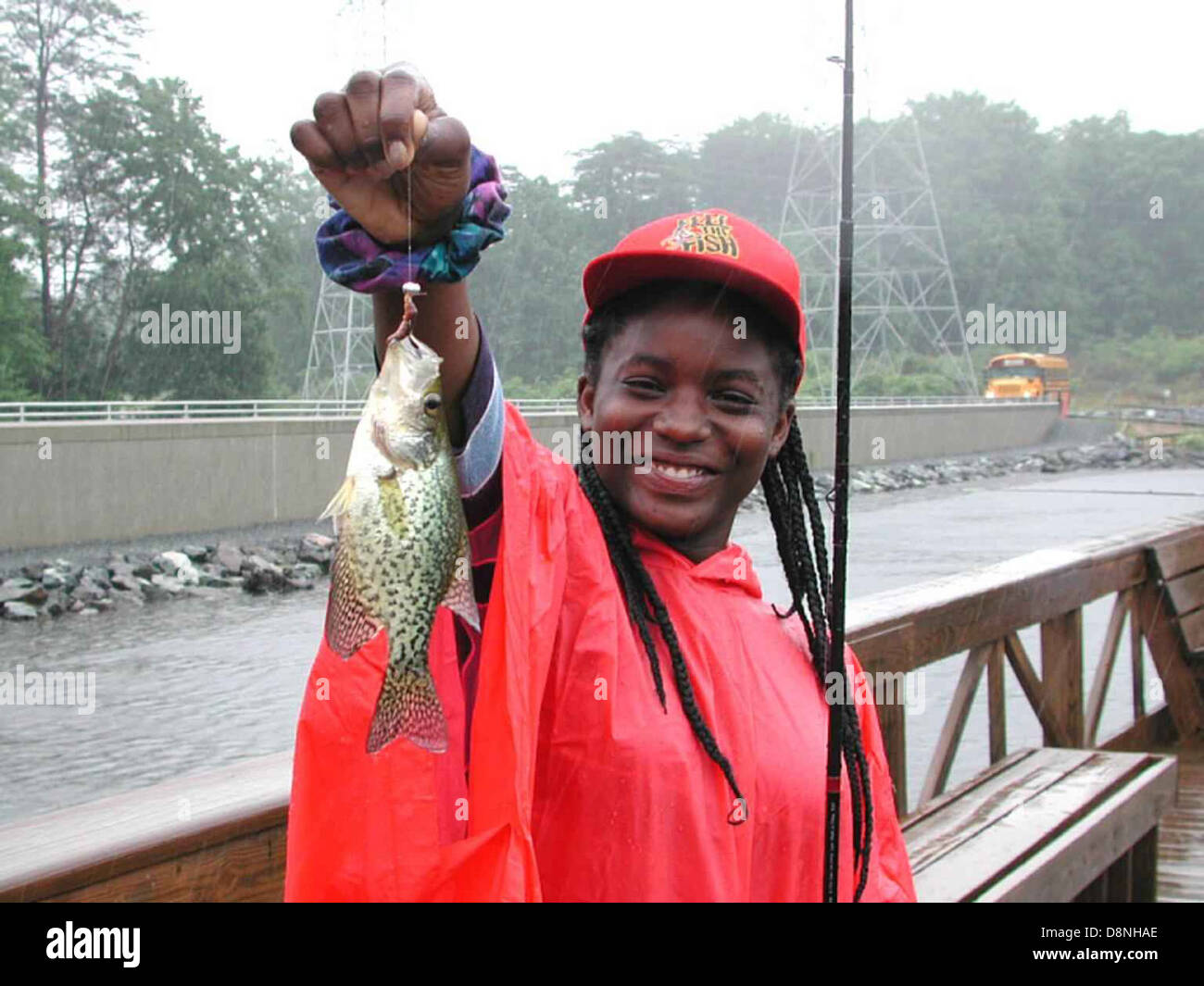 https://c8.alamy.com/comp/D8NHAE/young-african-american-teenage-girl-smile-and-enjoy-fishing-on-a-rainy-D8NHAE.jpg
