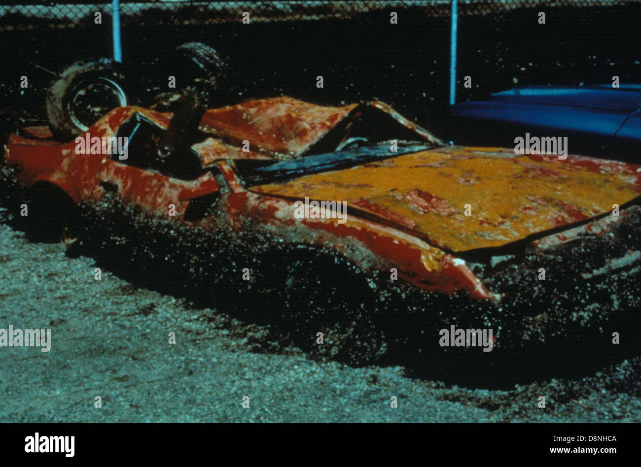 Zebra mussels encrust a damaged orange car. Stock Photo