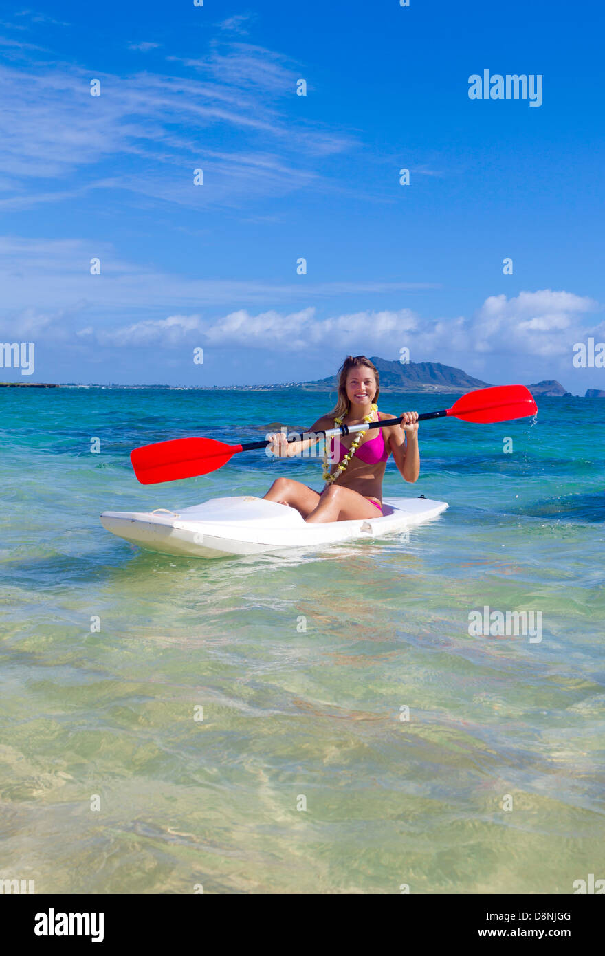 beautiful girl in bikini paddling her surf ski in hawaii Stock Photo