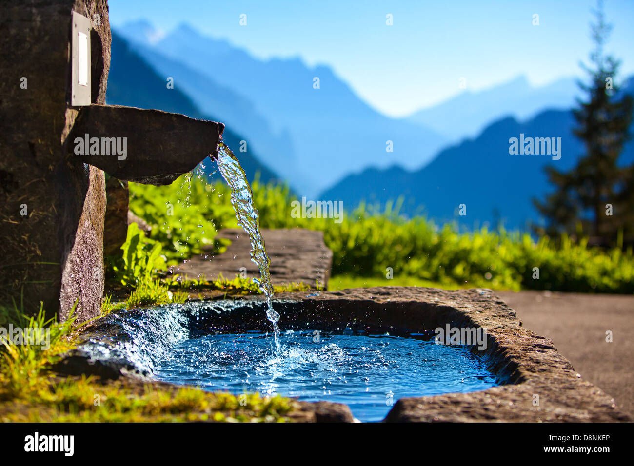 Water spring on Alps mountains background. Stock Photo