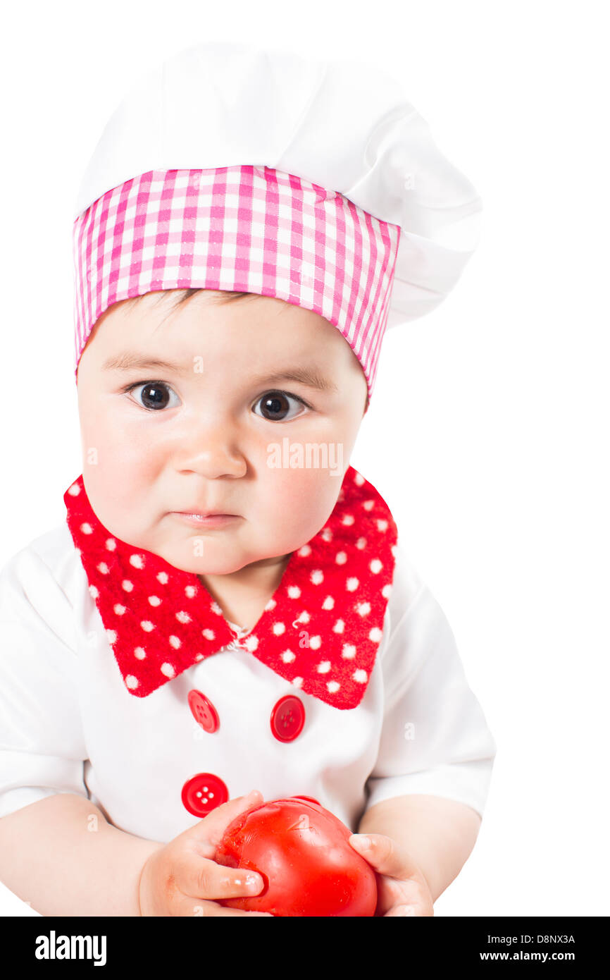 Baby girl wearing a chef hat with tomato . Use it for a child, healthy food concept Stock Photo
