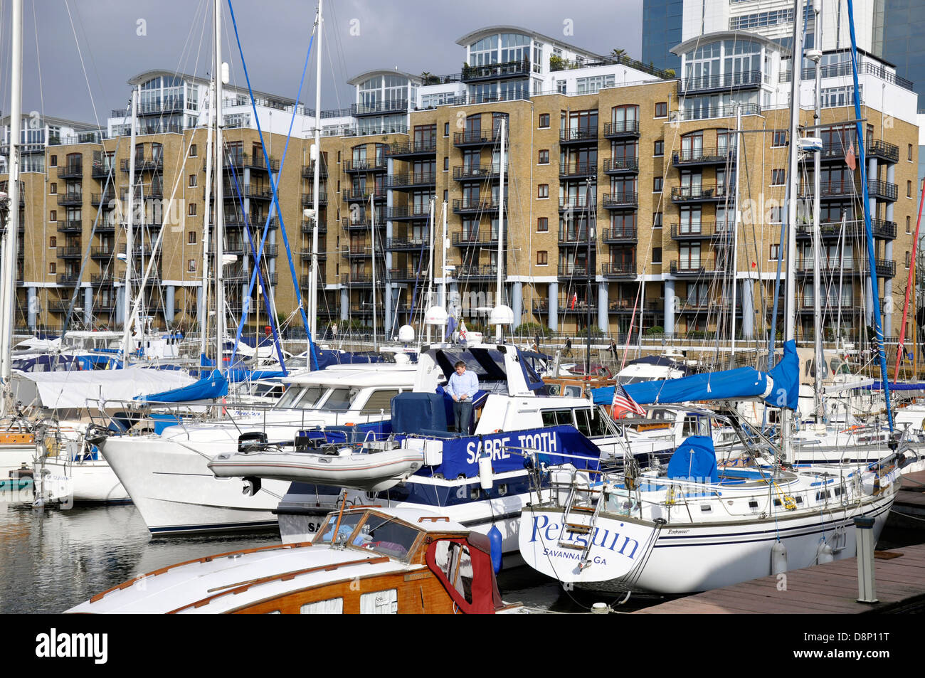 Man standing on a boat at St. Katharine Docks, with view of the marina