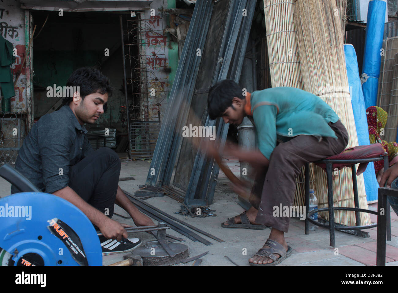 Workers at a iron and steel workshop in Old Delhi, India. Stock Photo