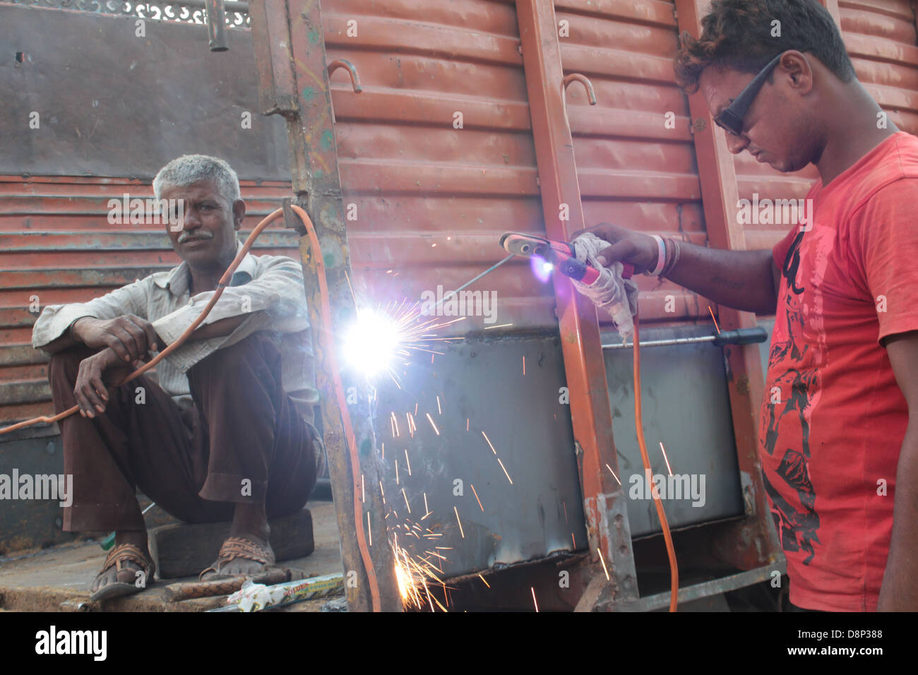 An Indian welder at work on a truck in Delhi. Stock Photo