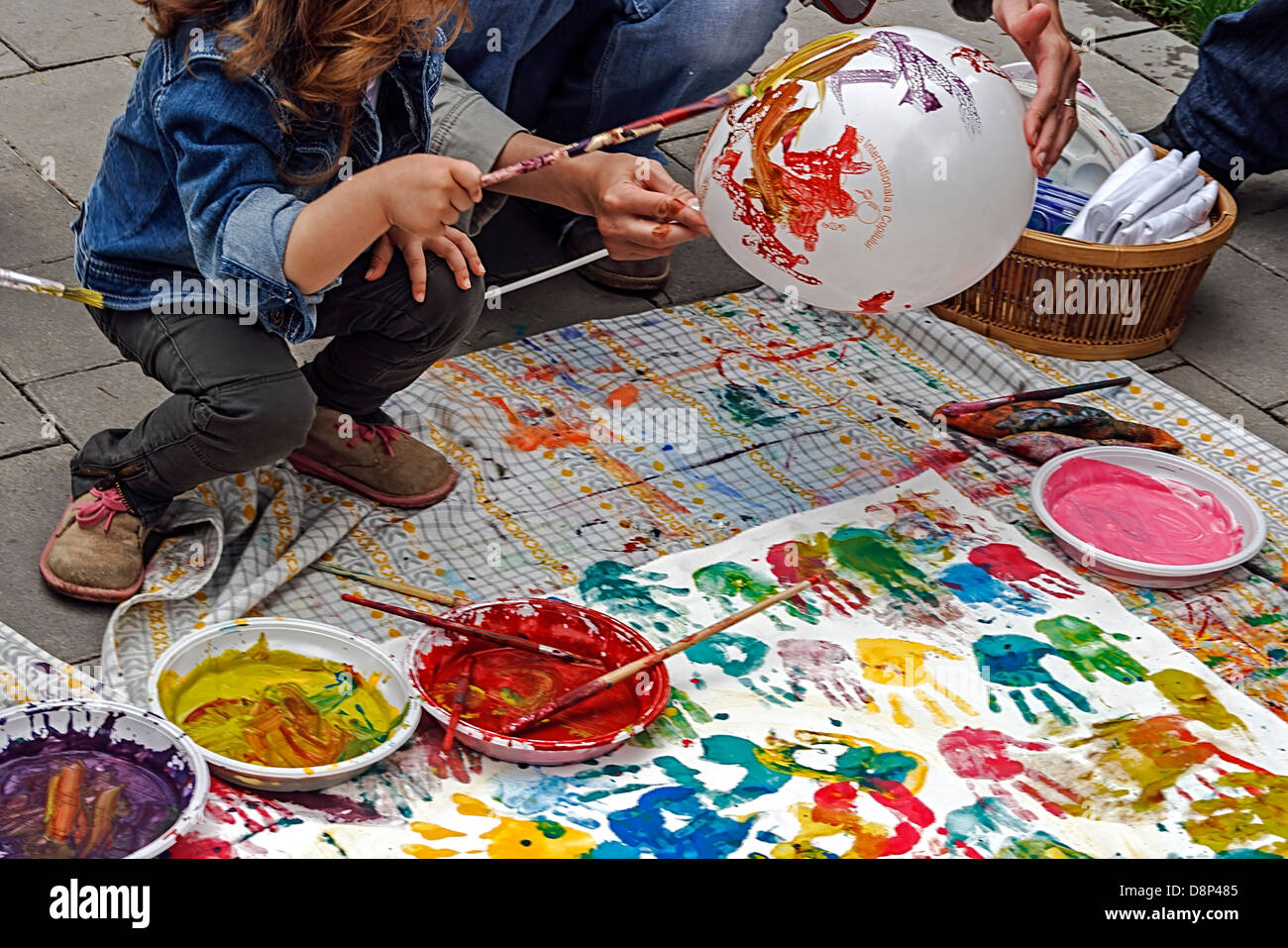 Child draw a balloon on a street workshop. Stock Photo