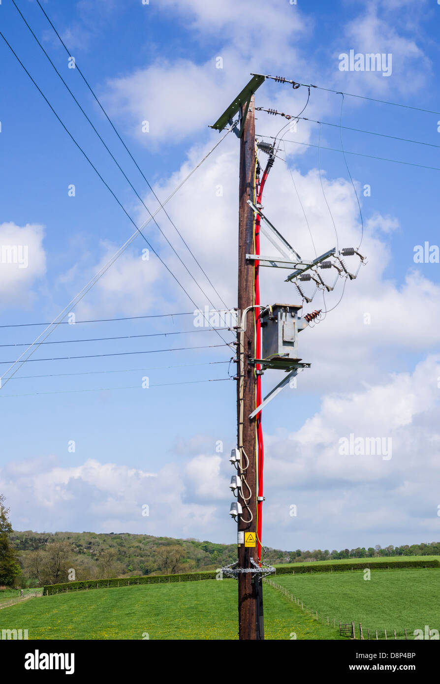 overhead Electricity cables carried on a pole in a rural area. Stock Photo