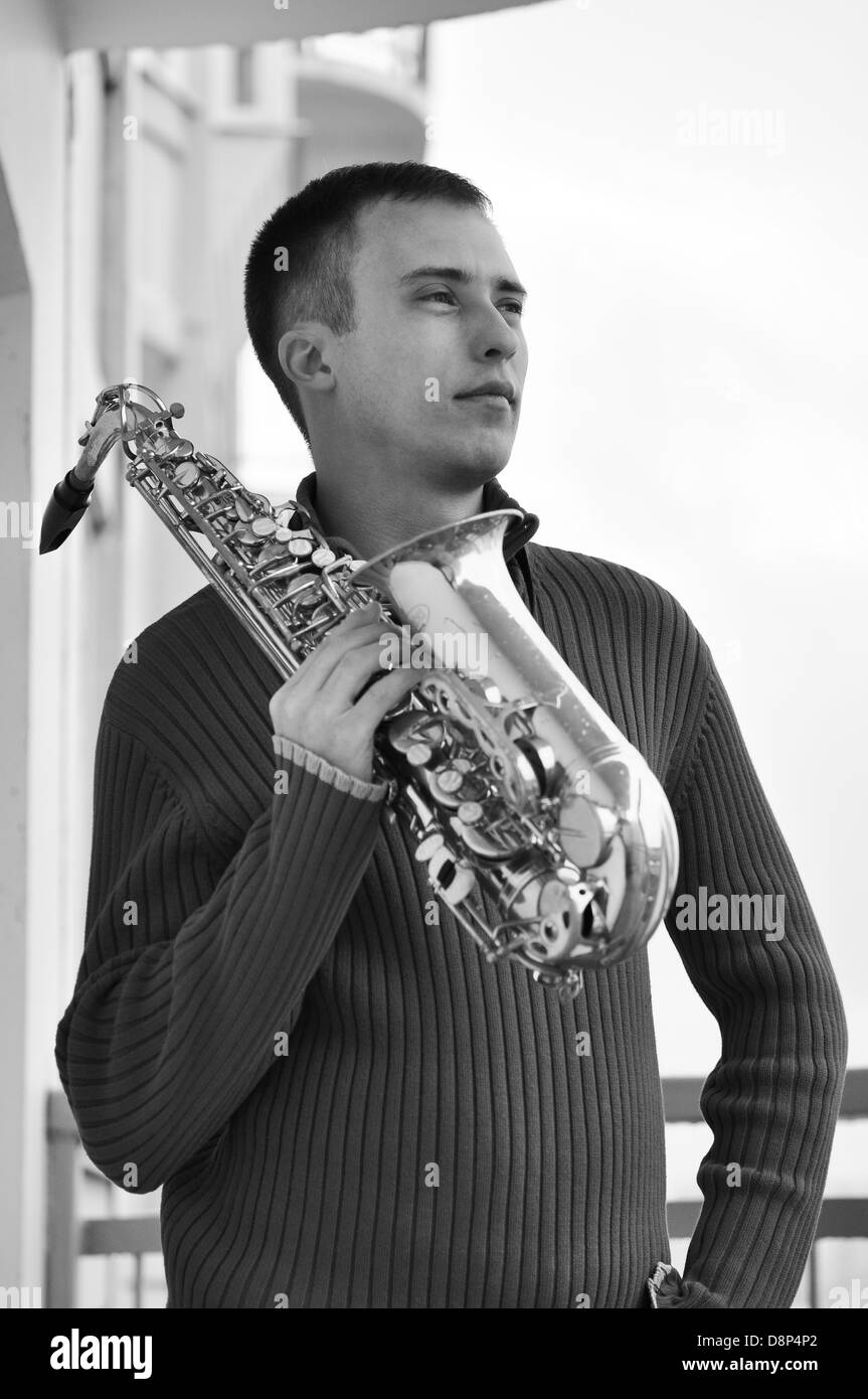 handsome young man playing on saxophone outdoor Stock Photo