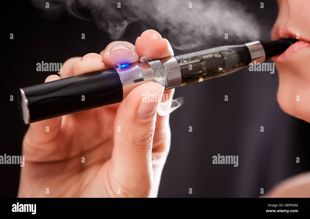 Close up of a woman inhaling from an electronic cigarette Stock Photo