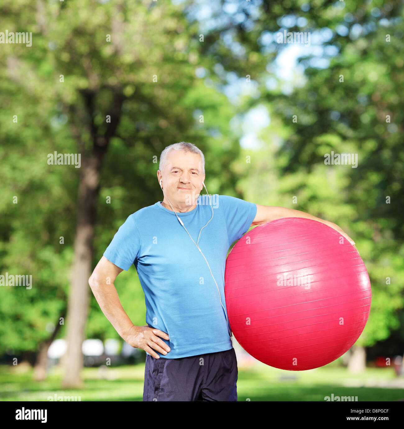 Mature sporty man holding a pilates ball in park Stock Photo