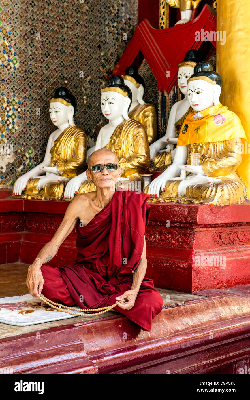 Buddhist monk praying Shwedagon Pagoda or Great Dagon Pagoda or Golden Pagoda Yangon (Rangoon) Burma Myanmar Stock Photo