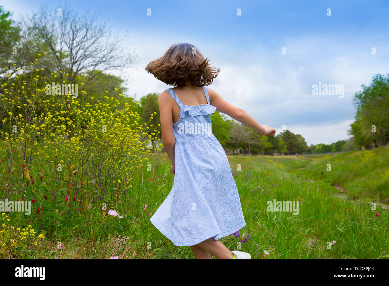 happy children girl jumping on spring poppy flowers meadow with motion blur Stock Photo