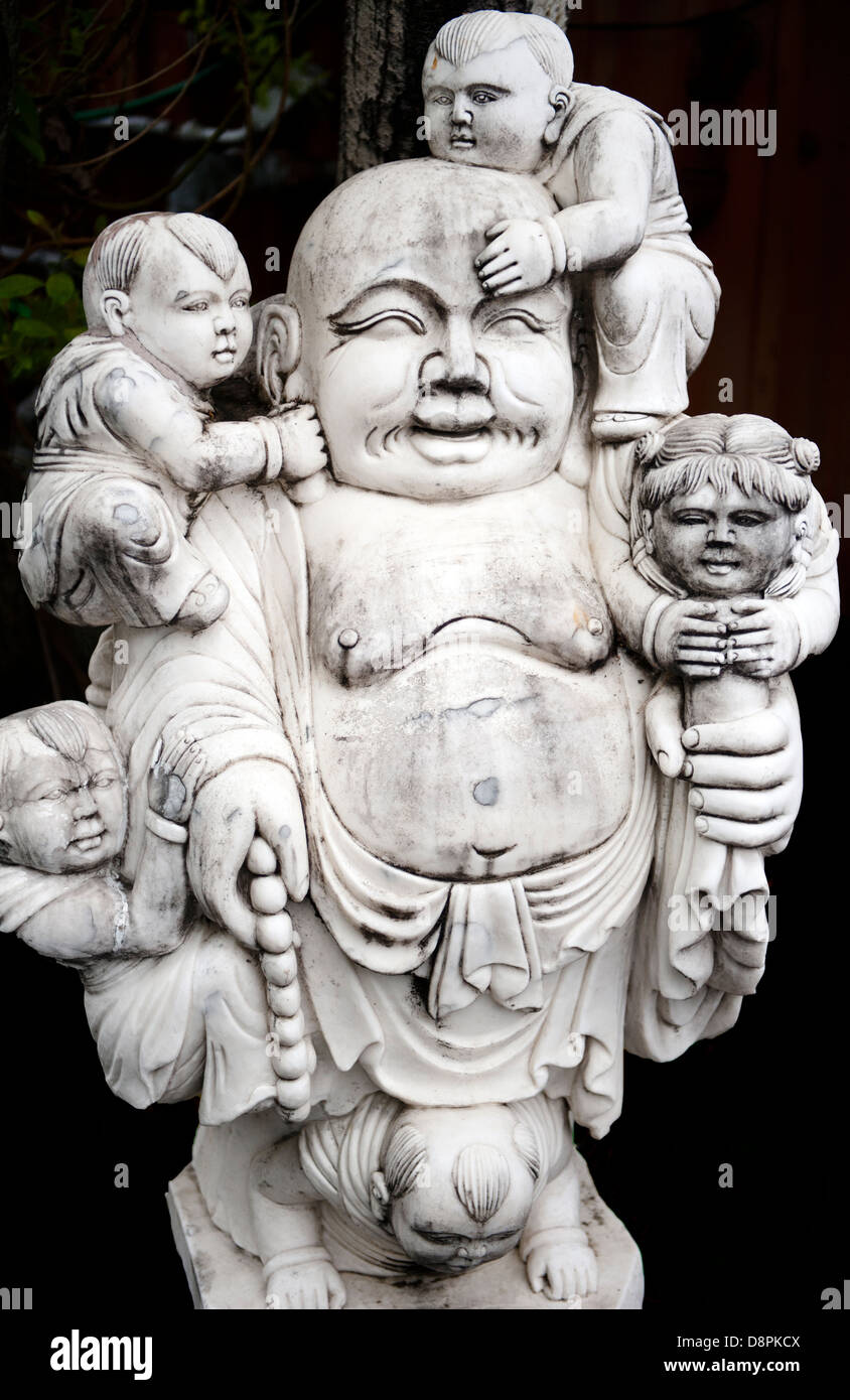 Unique Asian Buddha statue holding babies Stock Photo Alamy
