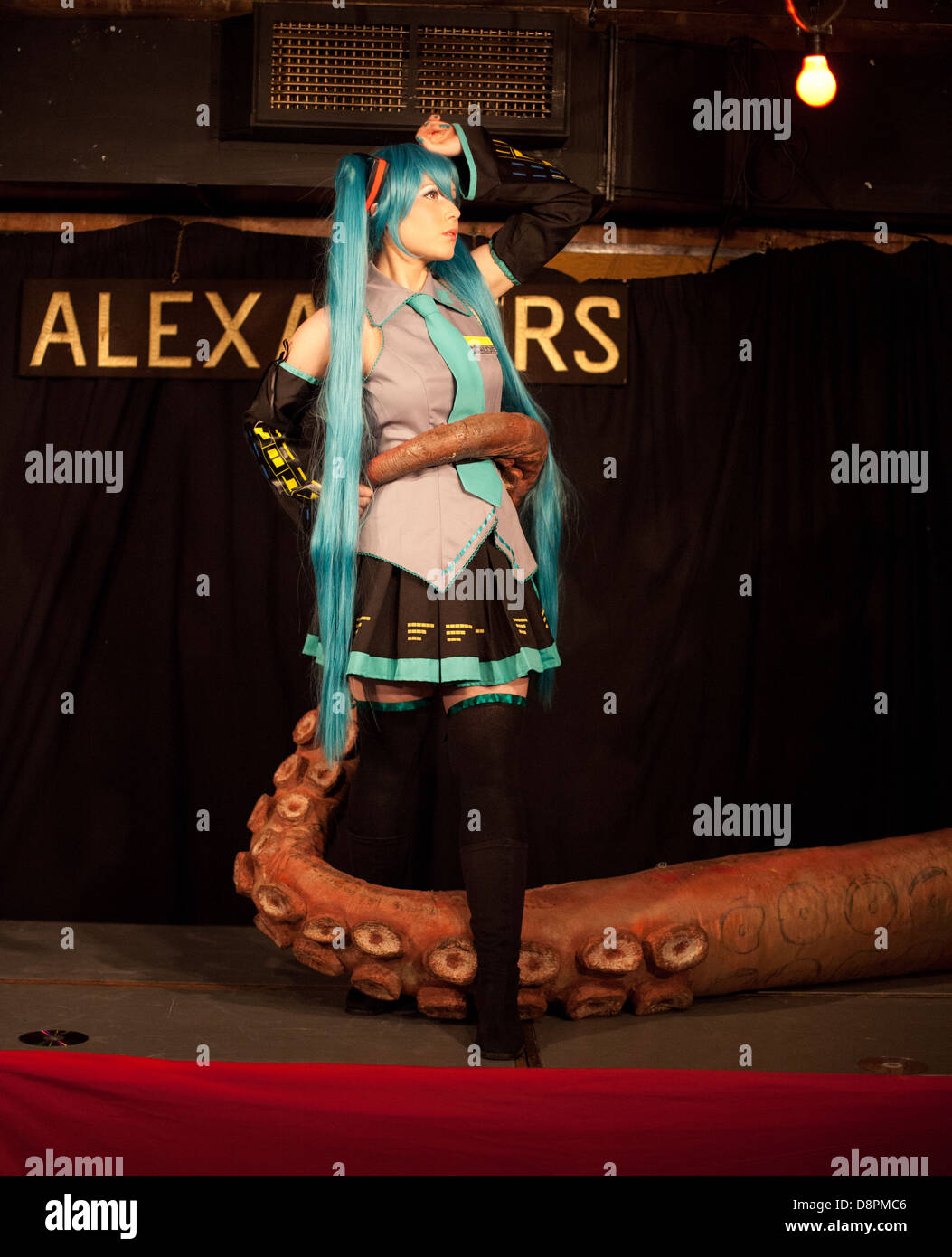 Cosplay /anime performer poses onstage with a big fake octopus tentacle at a Dr Sketchy burlesque life drawing event Stock Photo