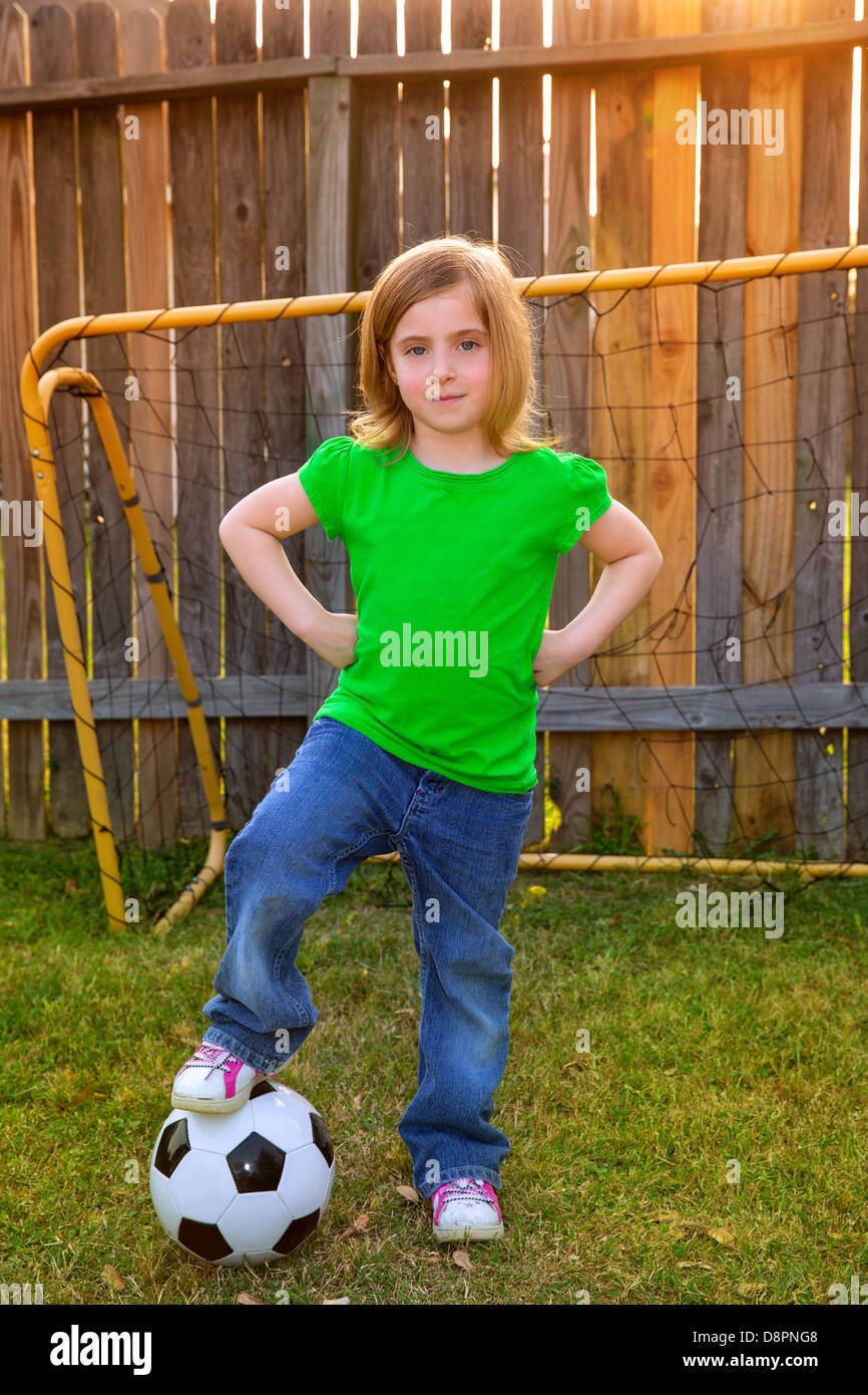 Blond little girl soccer player happy in backyard with ball Stock Photo