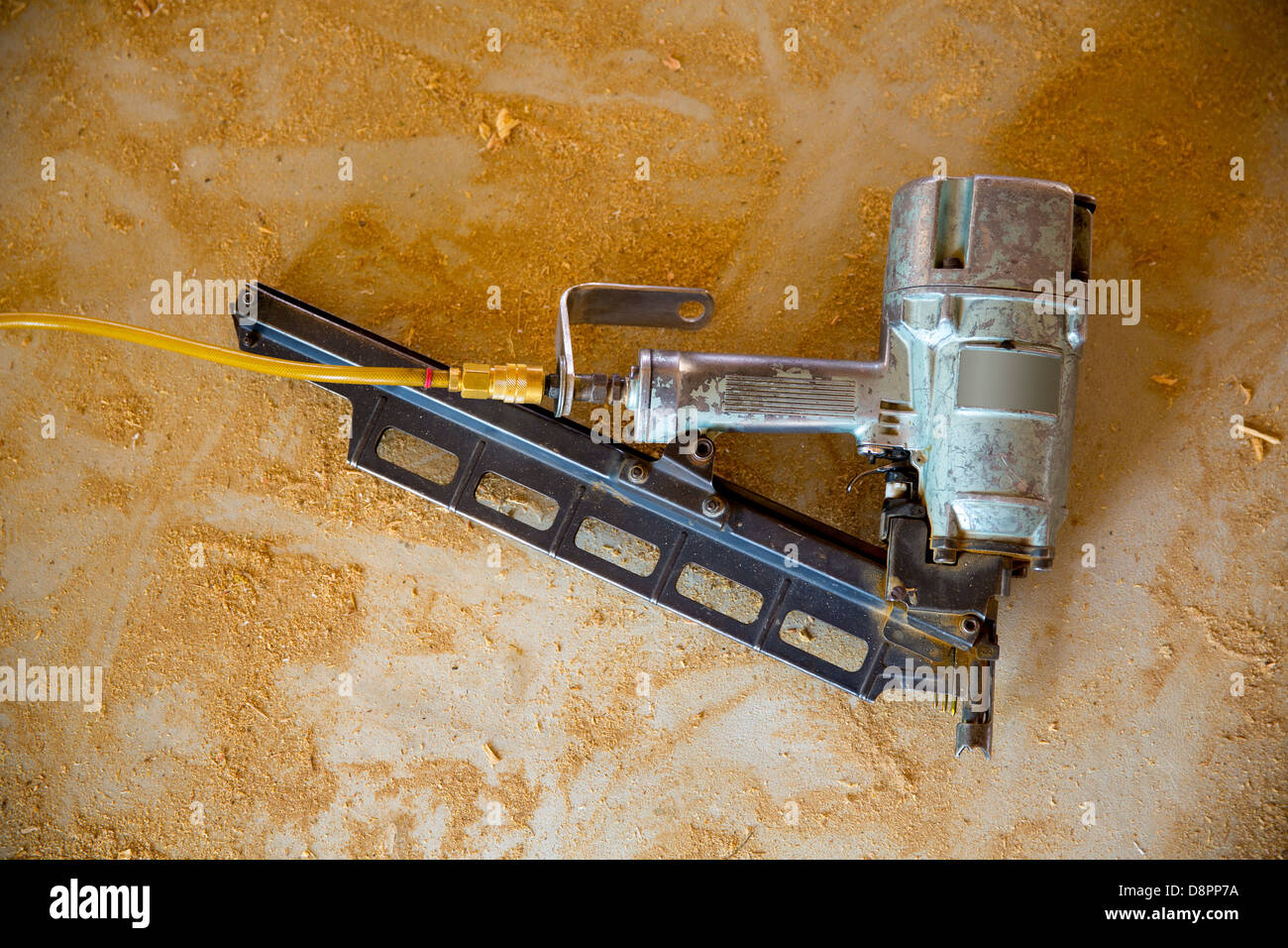Air nail gun pneumatic framing nailer on grunge sawdust floor while