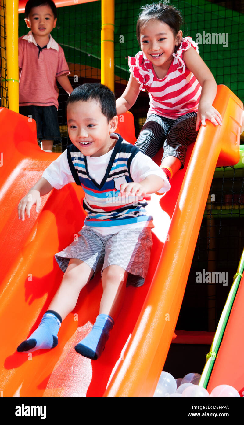 Young children playing on a slide Stock Photo