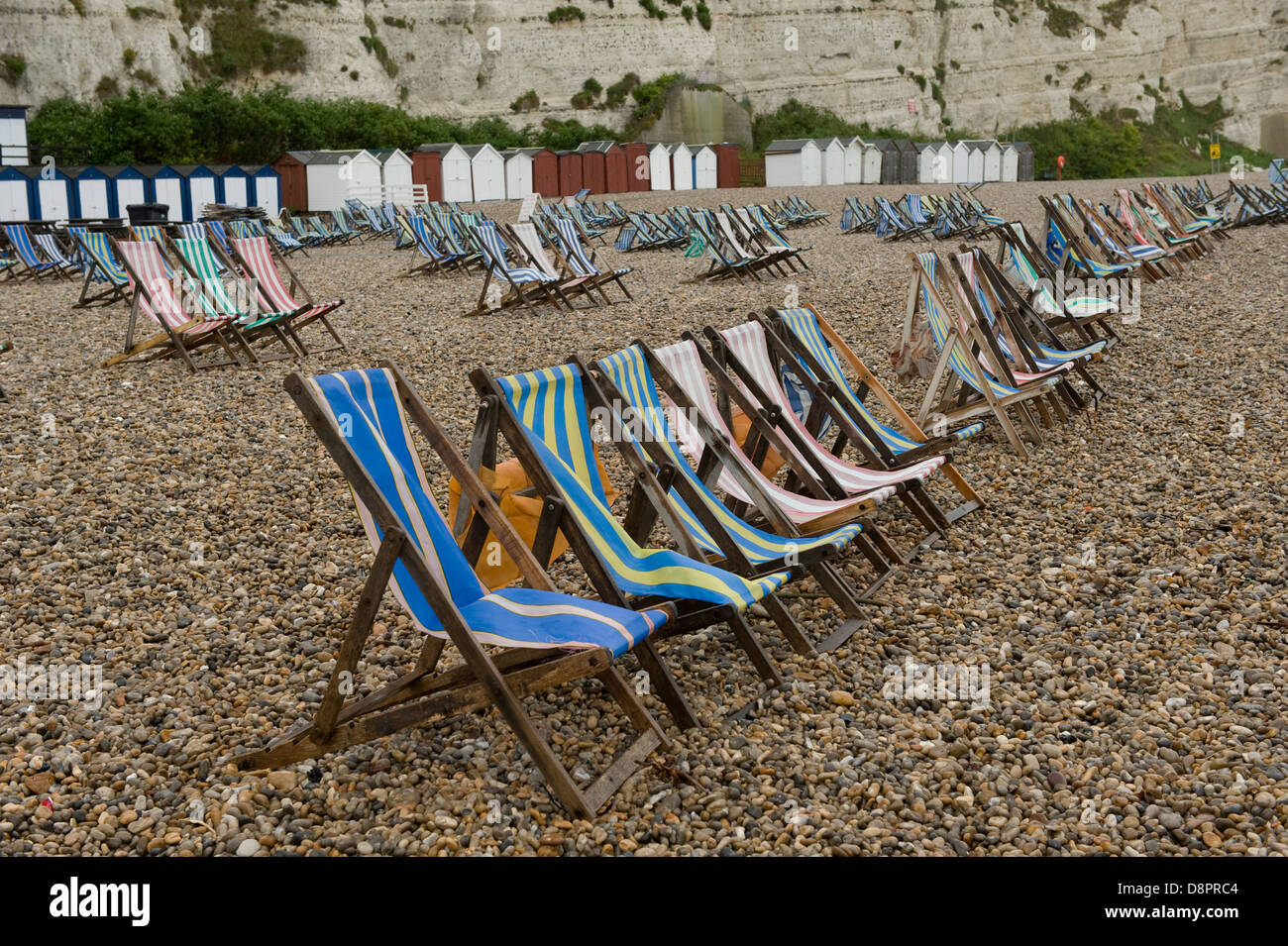 Wet summer day on Beer Beach in Devon with unused deck chairs Stock Photo