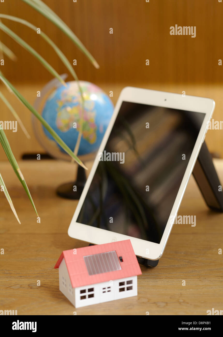 Tablet PC and a model of solar house Stock Photo