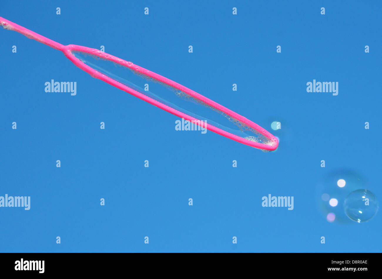 Bubble blowing wand against a deep blue sky. Stock Photo