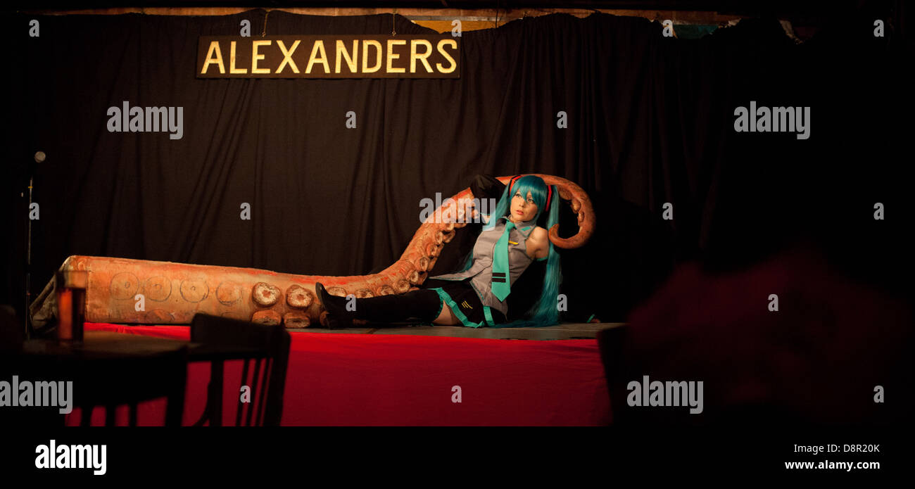 Cosplay /anime performer poses onstage with a big fake octopus tentacle at a Dr Sketchy burlesque life drawing event Stock Photo