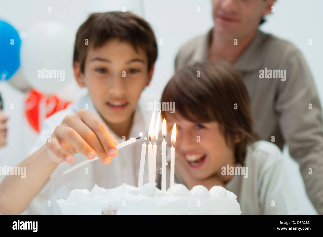Boy lighting candles on birthday cake Stock Photo Alamy