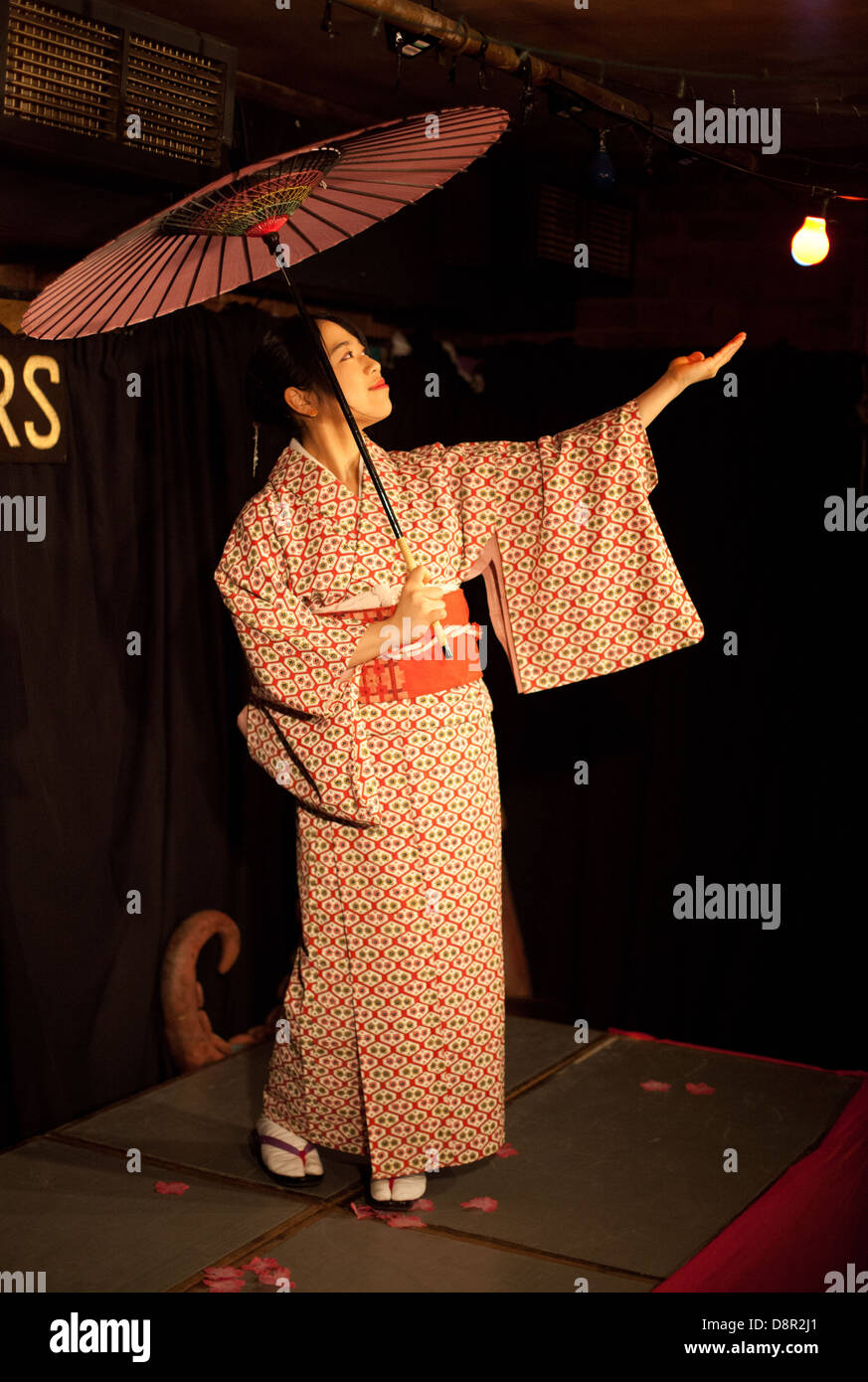 Young Japanese woman performs a traditional Japanese dance with parasol & kimono at a Dr Sketchy burlesque life drawing event Stock Photo