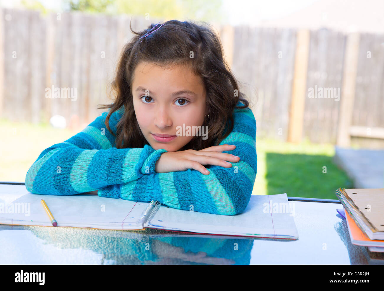 American latin teen girl relaxed on table doing homework on backyard Stock Photo - Alamy