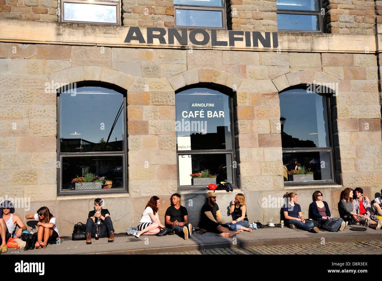Arnolfini art gallery Bristol, people sitting on pavement outside enjoying the sun Stock Photo