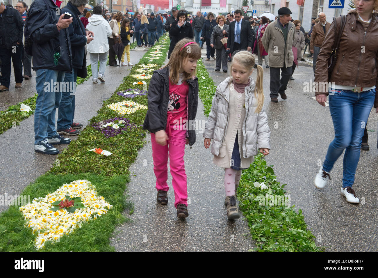 People walking on street decorated with wild flowers Easter Sunday Flower Torches Festival São Brás de Alportel Algarve Portugal Stock Photo