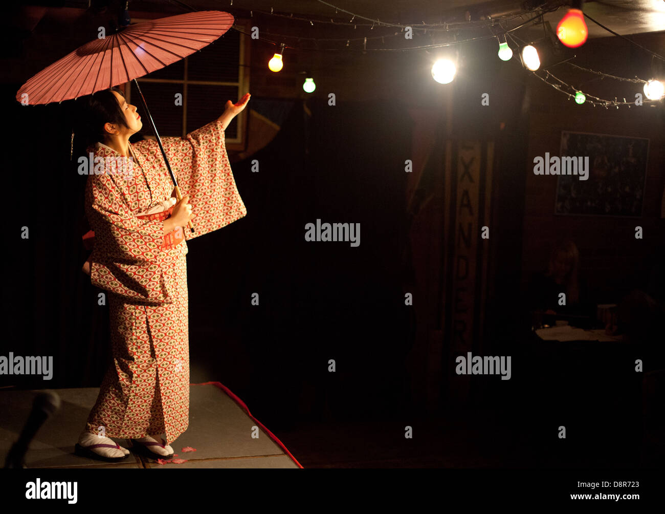 Young Japanese woman performs a traditional Japanese dance with parasol & kimono at a Dr Sketchy burlesque life drawing event Stock Photo