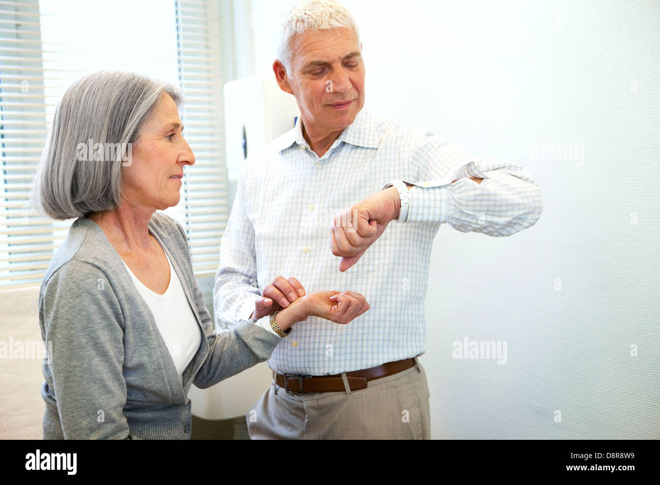 TAKING AN ELDERLY PERSON'S PULSE Stock Photo