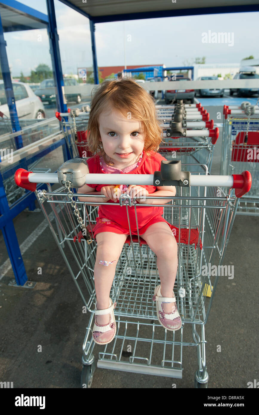 Little girl sitting in shopping cart Stock Photo Alamy