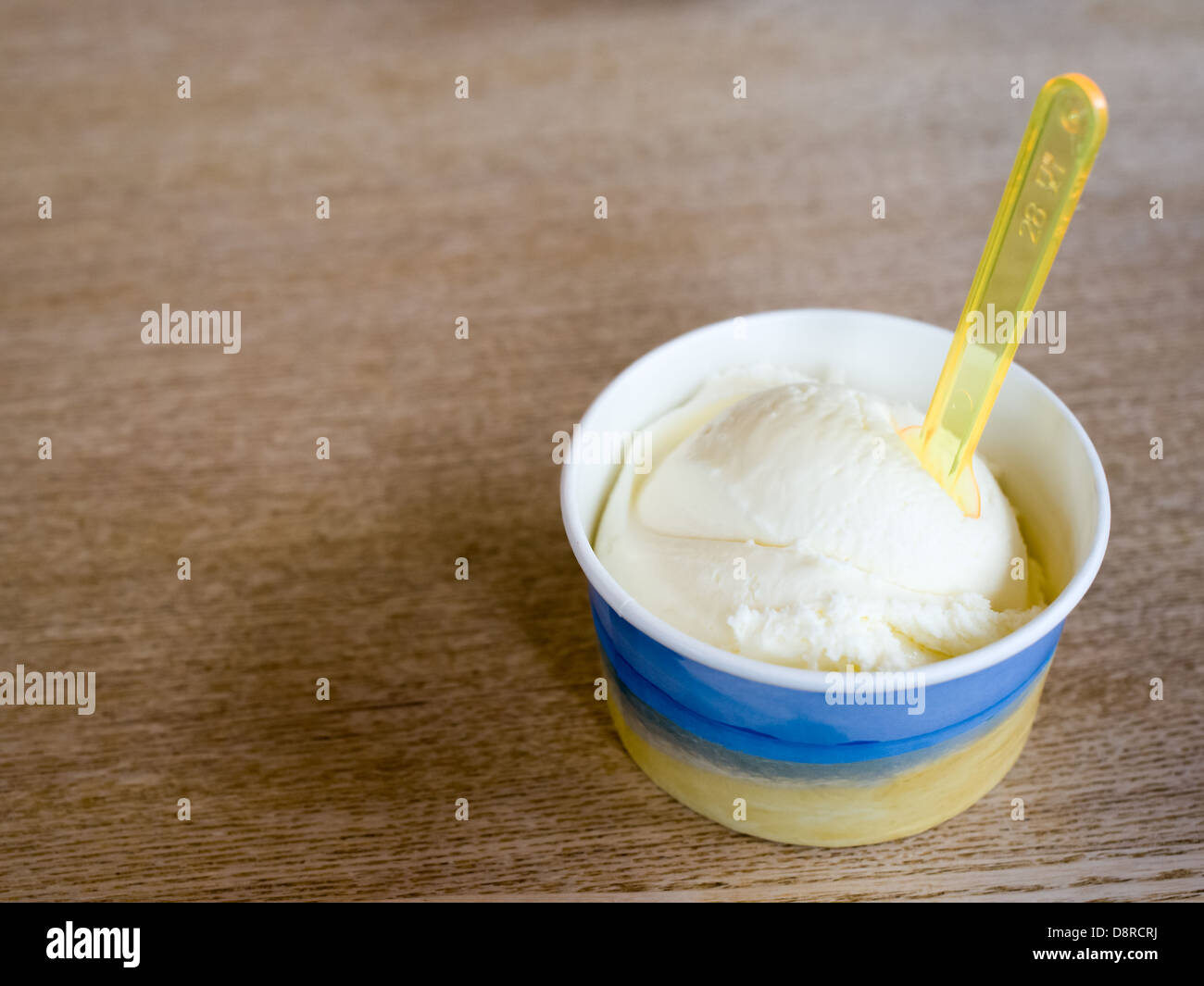 https://c8.alamy.com/comp/D8RCRJ/vanilla-ice-cream-tub-with-spoon-on-a-wooden-table-D8RCRJ.jpg
