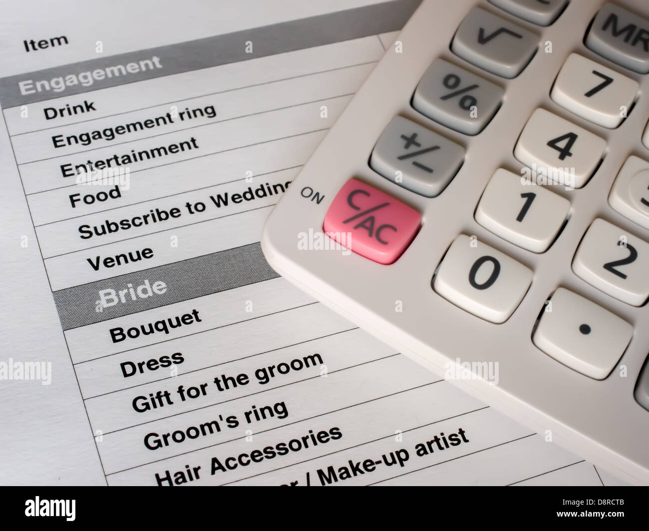 Planning a wedding using a printed list with a calculator to represent the  cost Stock Photo - Alamy