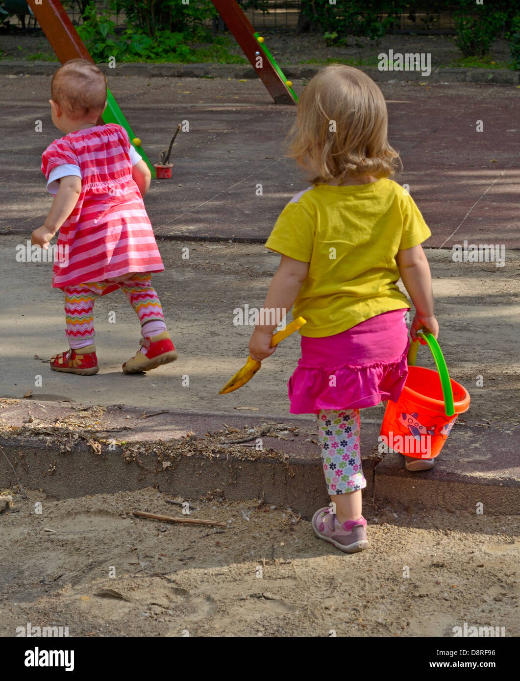 Two little girls walking at playground Stock Photo