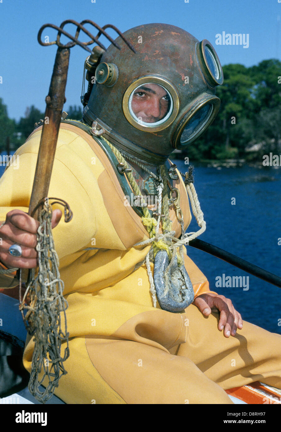 A young sponge diver in a traditional hardhat bell diving suit enters