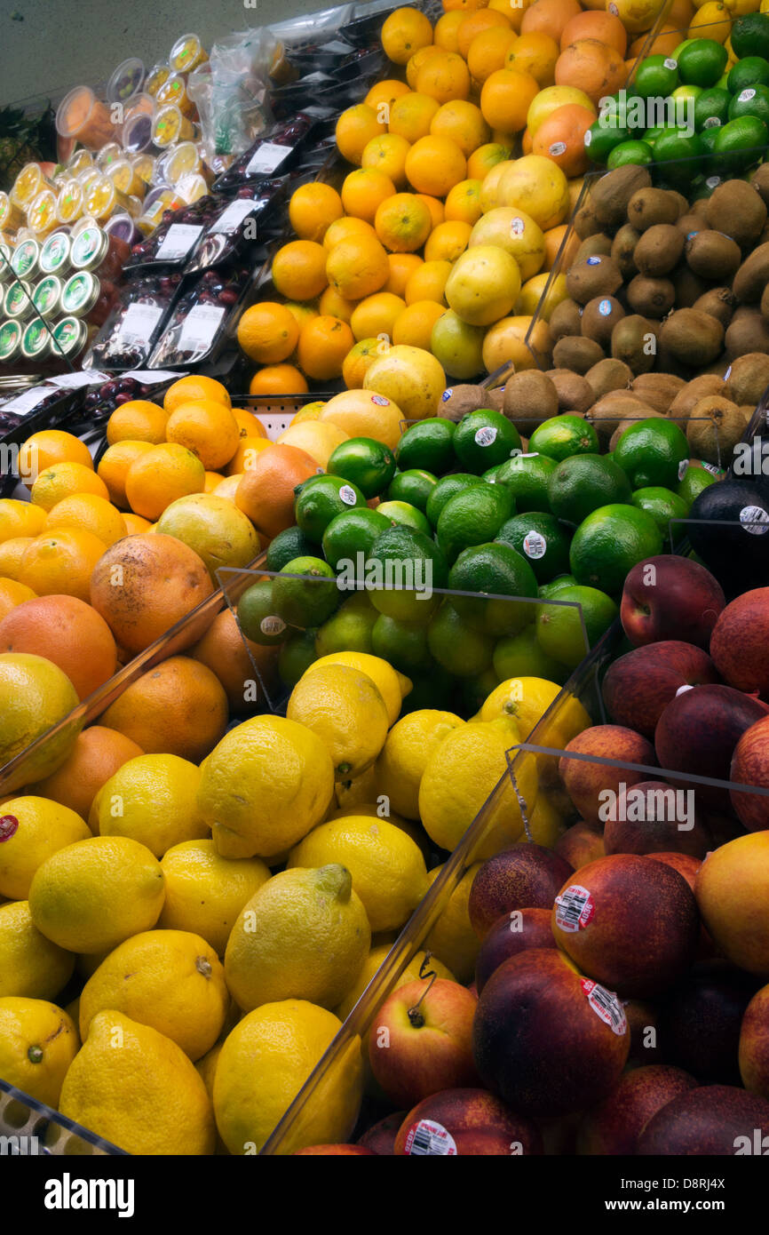 Lemons, limes, oranges and peaches on display in grocery store produce section. Stock Photo