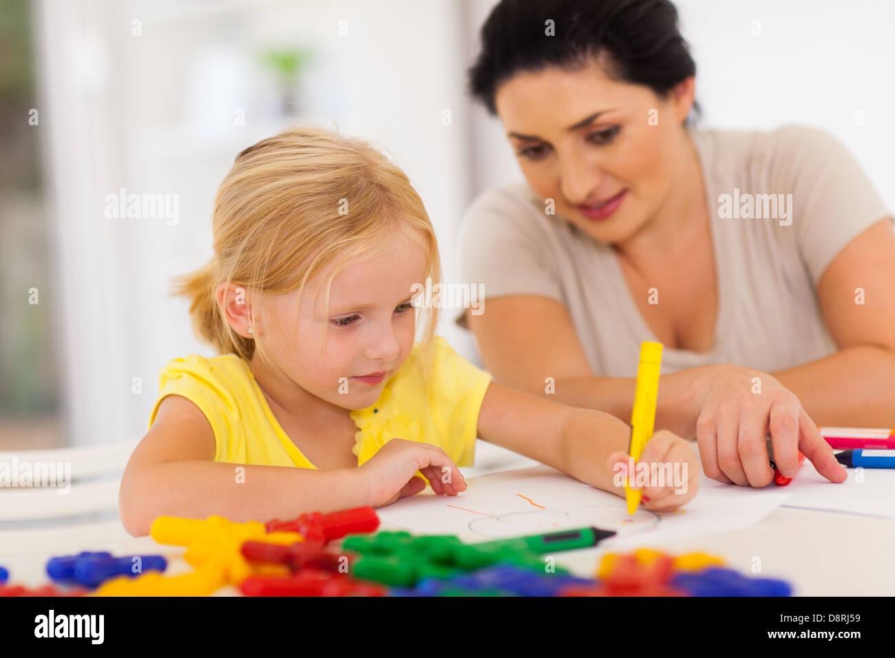 cute little girl drawing with mother at home Stock Photo - Alamy