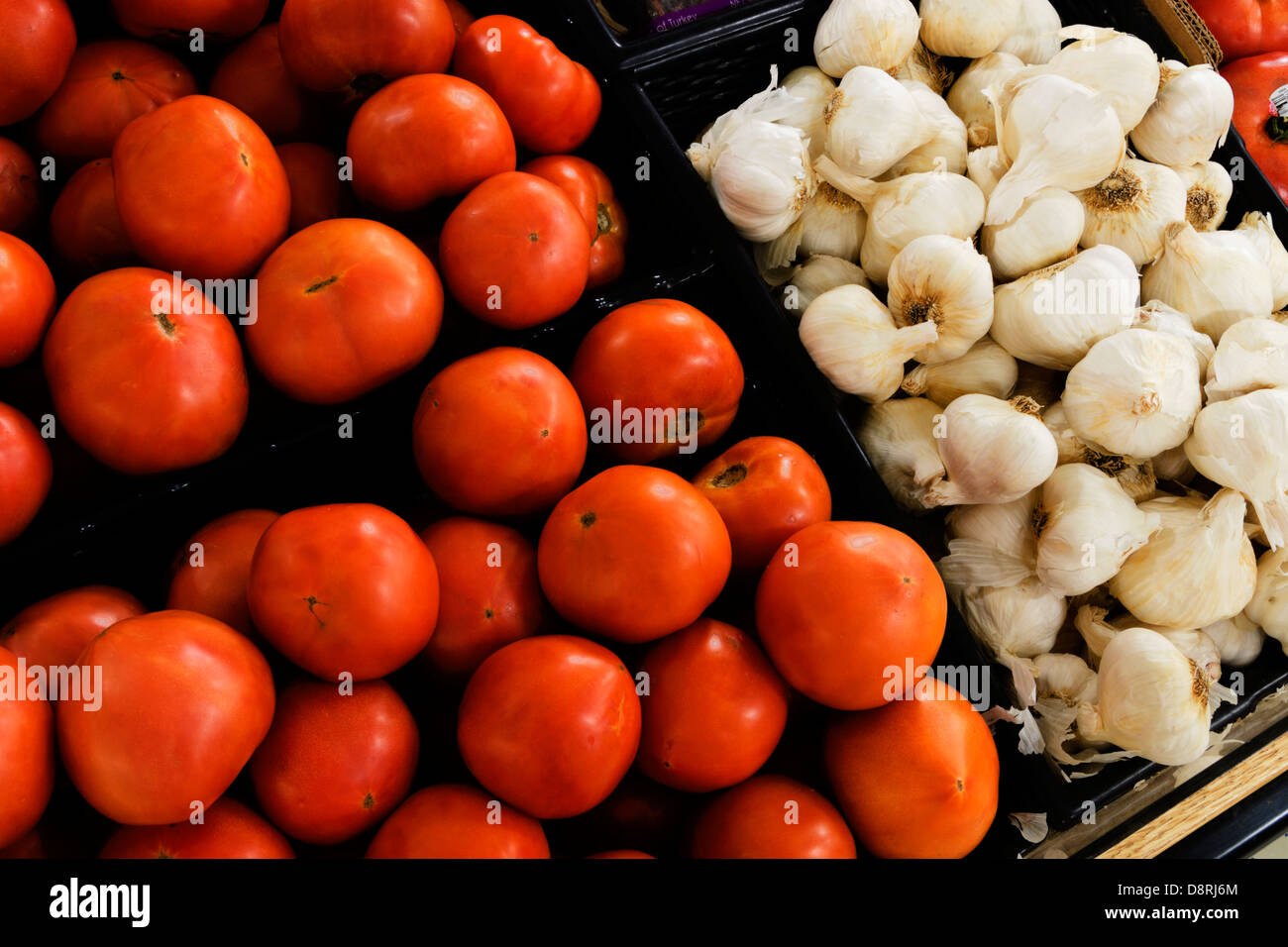 Tomatoes and garlic on display in a family owned grocery store. Stock Photo