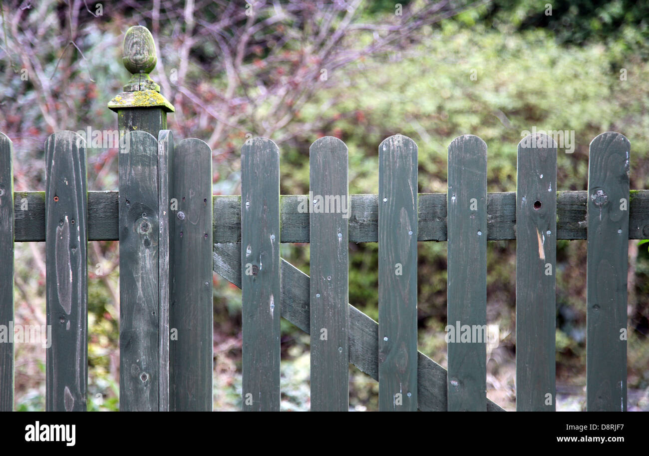 It's a photo of a wood gate made of boards that is around a garden, park of Field. It's an old one and look vanished. Stock Photo