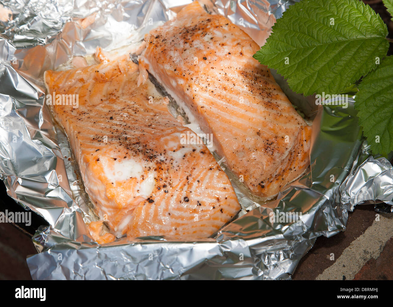 Salmon cooked in foil on barbecue Stock Photo - Alamy