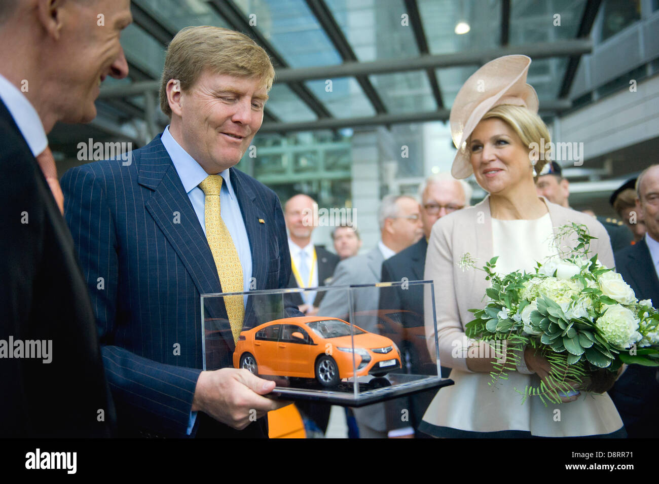 Ruesselsheim, Germany. 4th June 2013. Dutch King Willem-Alexander (C) and Queen Maxima are presented with anorange model of the hybrid car Opel Ampera by CEo of Adam Opel AG, Karl-Thomas Neumann (L), in Ruesselsheim. The Dutch royal couple is on a two-day visit to Germany. Photo: NICOLAS ARMER/dpa/Alamy Live News Stock Photo