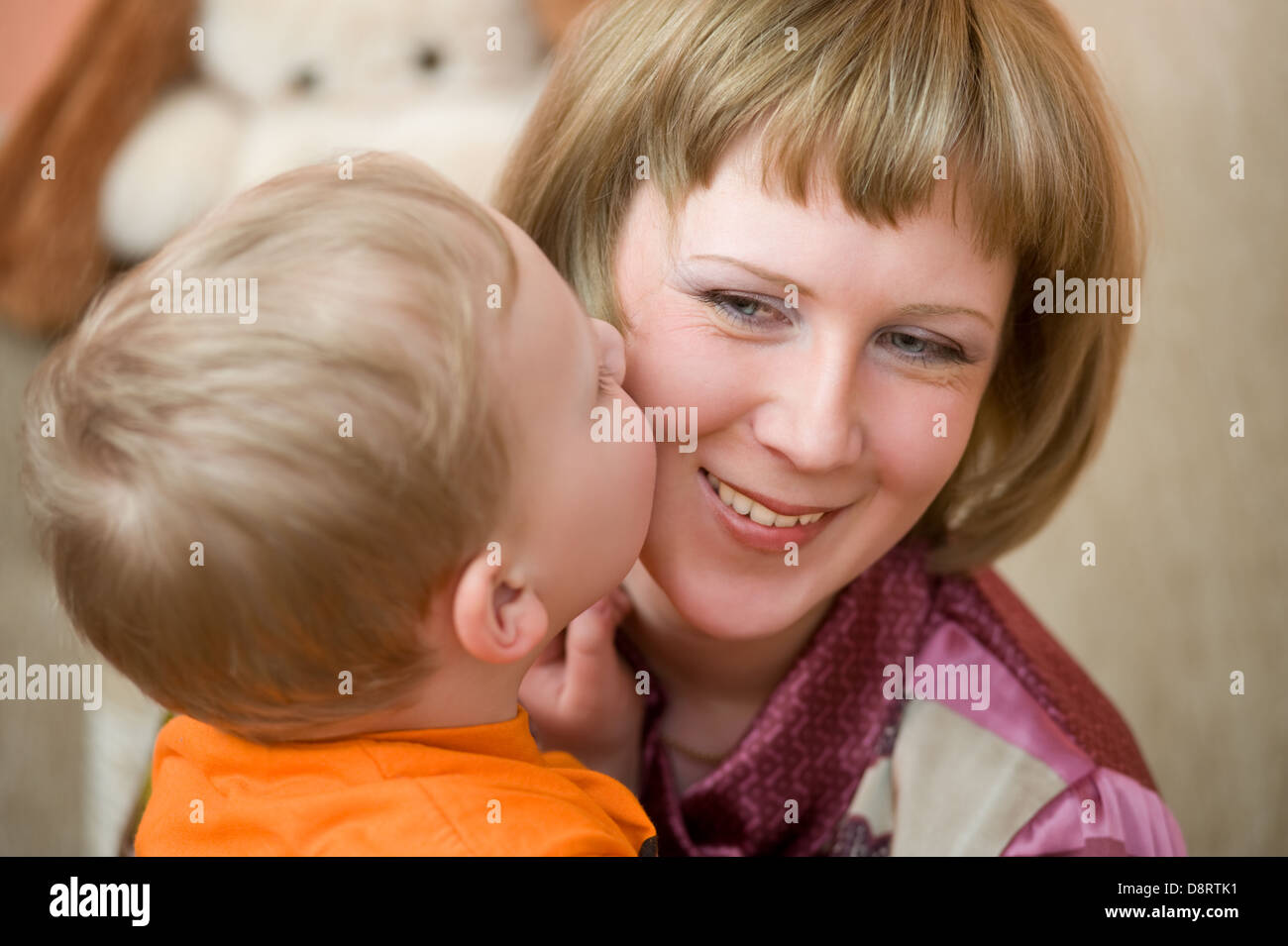little son kisses his Mom Stock Photo
