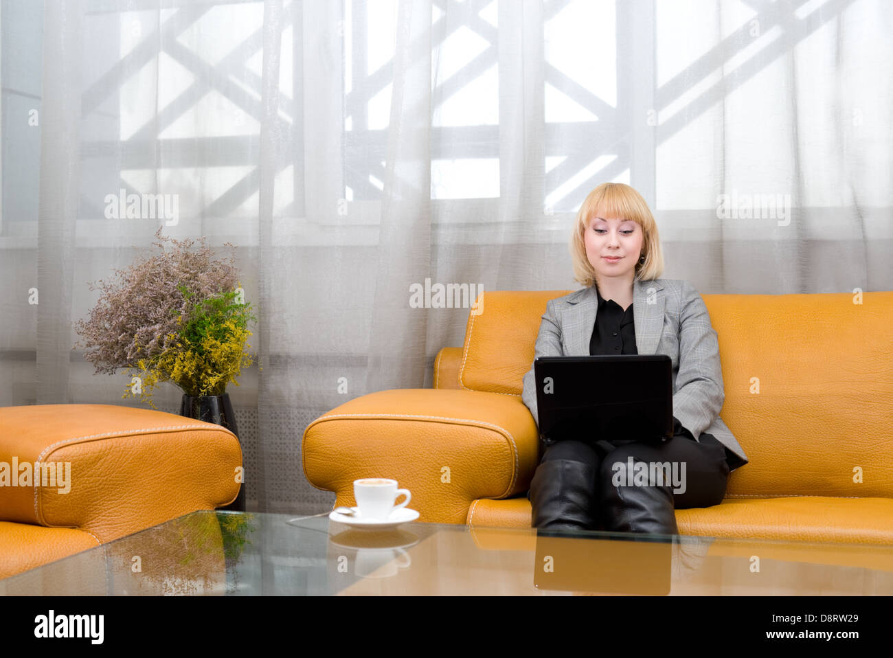 blonde woman with laptop in comfort hall Stock Photo