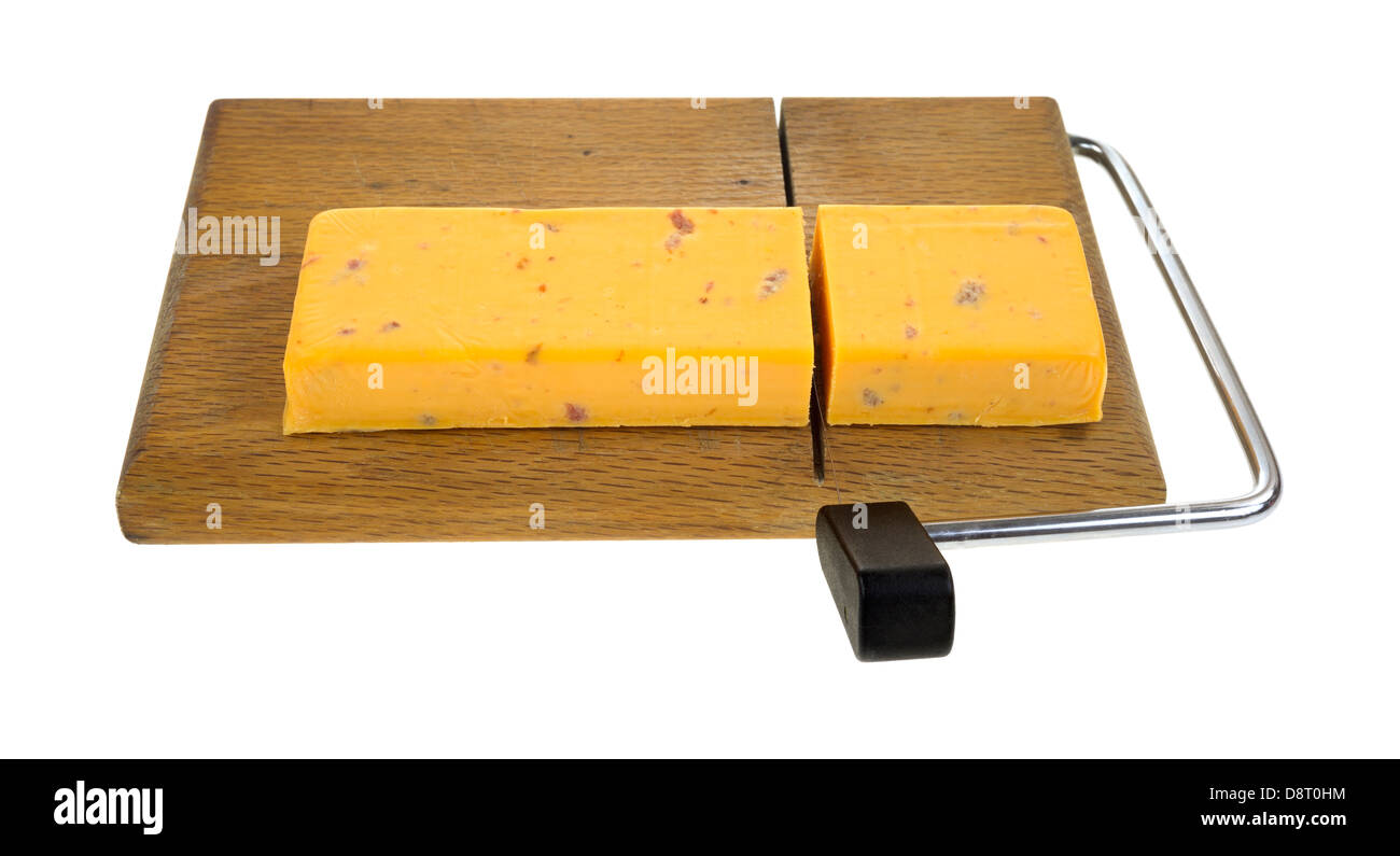 A chunk of cheddar cheese with salami that has been sliced on a cutting board. Stock Photo