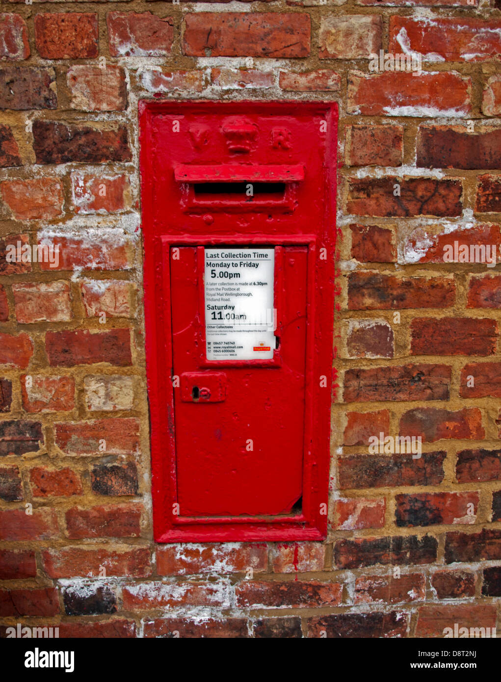 A traditional red English letterbox mounted in a wall, Wellingborough, Northamptonshire, England