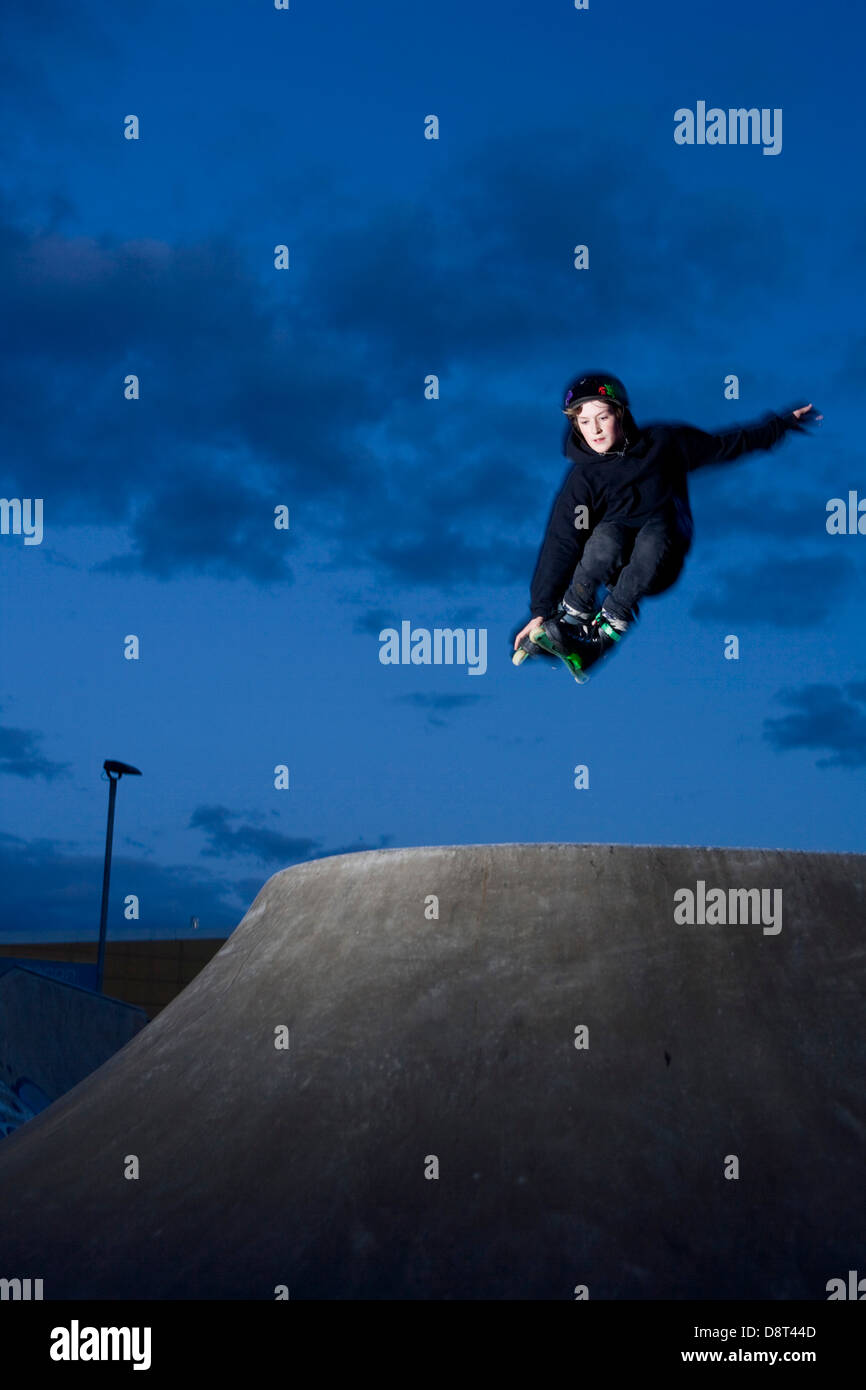 Young Inline skater jumping in a skate park. Stock Photo